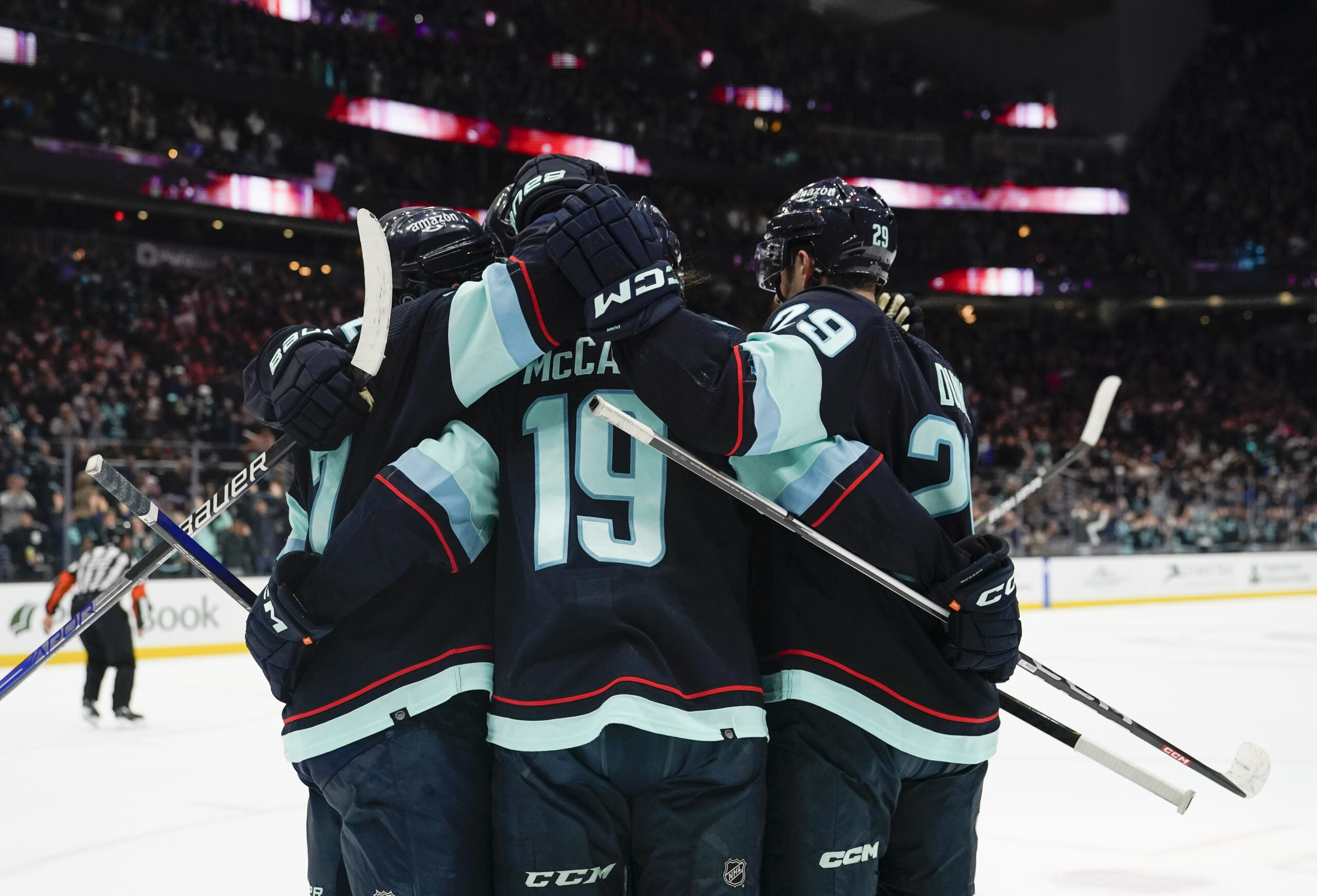 Seattle Kraken left wing Jared McCann (19) and teammates celebrate his goal against the Arizona Coyotes during the first period of an NHL hockey game Thursday, April 6, 2023, in Seattle.