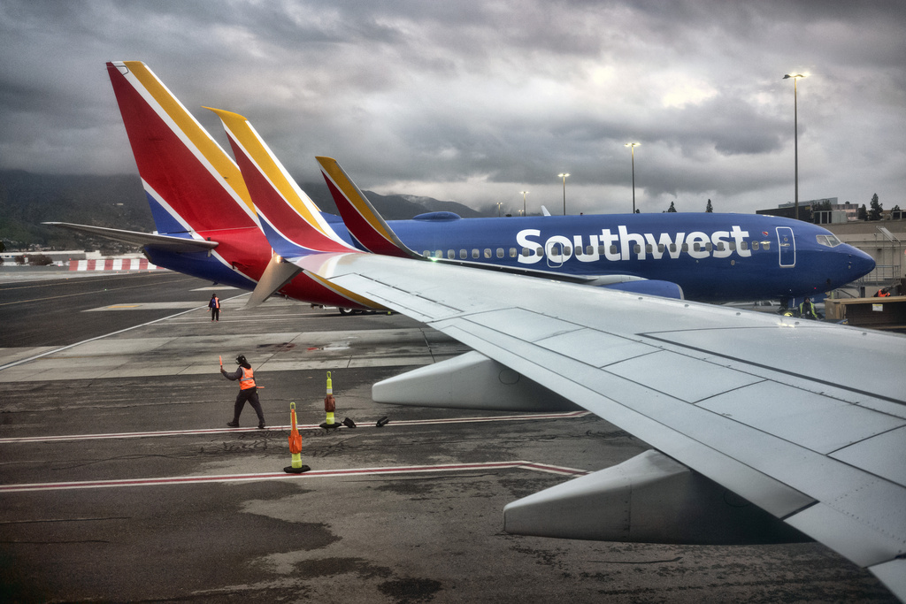 FILE - A Southwest Airlines ground crew directs a plane out of the terminal at Hollywood Burbank Airport in Burbank, Calif. on Feb. 14, 2023.