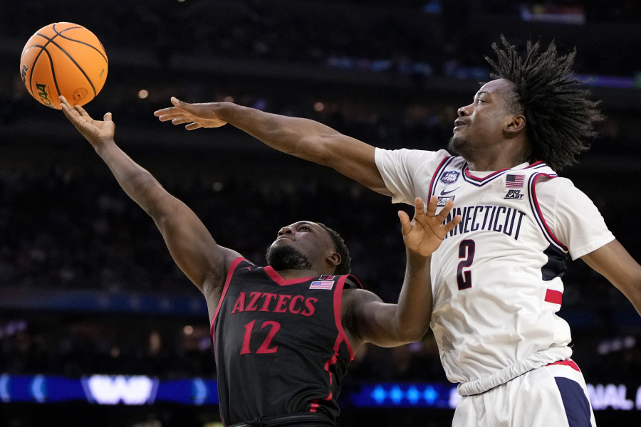Connecticut guard Tristen Newton (2) blocks a shot by San Diego State guard Darrion Trammell during the second half of the men's national championship college basketball game in the NCAA Tournament on Monday, April 3, 2023, in Houston. (AP Photo/David J.