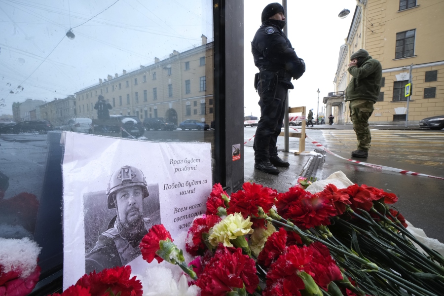 Flowers and a poster with a photo of blogger Vladlen Tatarsky placed near the site of an explosion at the "Street Bar" cafe in St. Petersburg, Russia, Monday, April 3, 2023. An explosion tore through a cafe in Russia's second-largest city, killing a well-known military blogger and strident supporter of the war in Ukraine. Some reports said a bomb was embedded in a bust of the blogger that was given to him as a gift. Russian officials said Vladlen Tatarsky was killed Sunday as he led a discussion at the cafe in the historic heart of St. Petersburg.