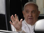 Pope Francis waves from his car as he arrives at The Vatican, Saturday, April 1, 2023, after receiving treatment at the Agostino Gemelli University Hospital for bronchitis, The Vatican said. Francis was hospitalized on Wednesday after his public general audience in St. Peter's Square at The Vatican.