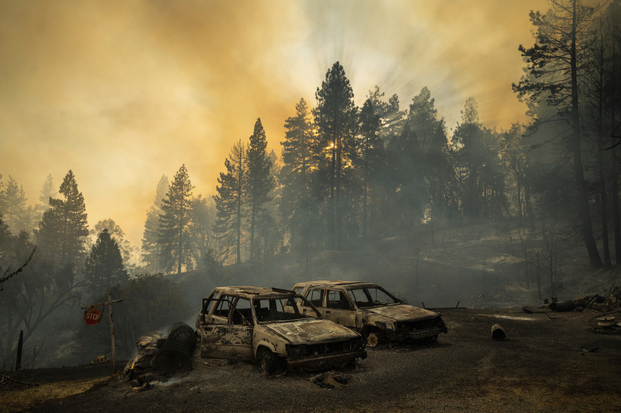 FILE - Scorched vehicles rest in a clearing as the Mosquito Fire burns along Michigan Bluff Rd. in unincorporated Placer County, Calif., Sept. 7, 2022. An overwhelming majority of the U.S. public say they have recently experienced extreme weather, and most of them attribute that to climate change, according to a new poll from The Associated Press-NORC Center for Public Affairs Research.