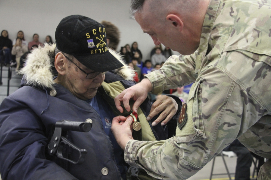 This March 28, 2023, photo shows Bruce Boolowon, left, as Maj. Gen. Torrence Saxe, the adjutant general of the Alaska National Guard, affixes his Alaska Heroism Medal during a ceremony in Gambell, Alaska. Boolowon is the last surviving guardsman of 16 who helped rescue 11 Navy crewmen after they crash landed on St. Lawrence Island June 22, 1955, and the family members of the 15 deceased guardsman accepted the medals.