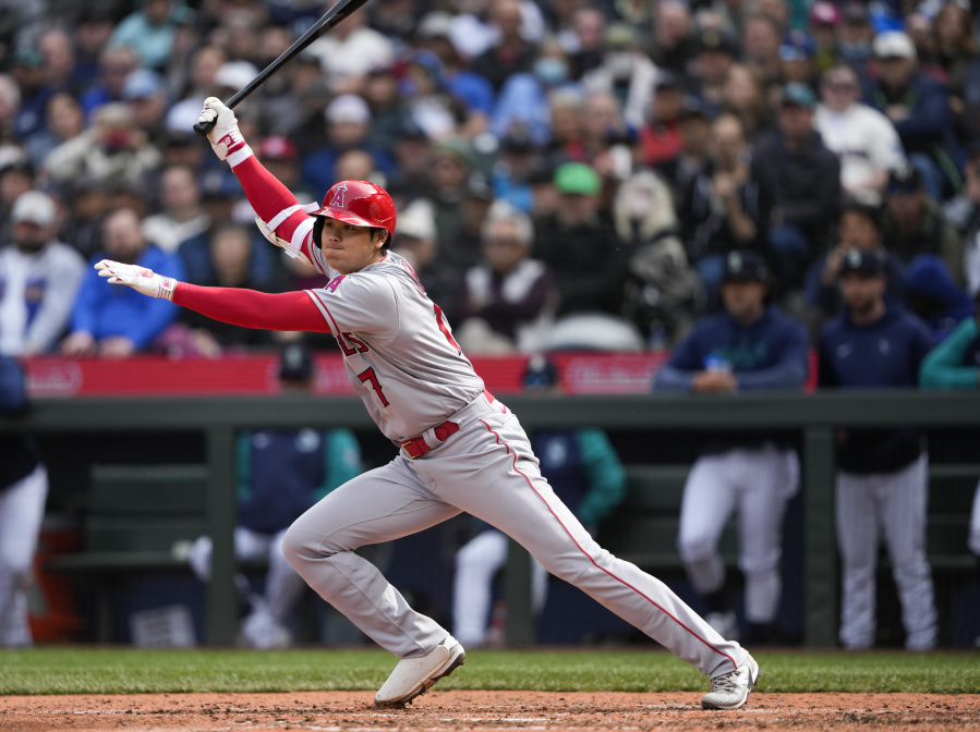 Los Angeles Angels' Shohei Ohtani follows through on an RBI single to score Taylor Ward during the seventh inning of a baseball game against the Seattle Mariners, Wednesday, April 5, 2023, in Seattle.