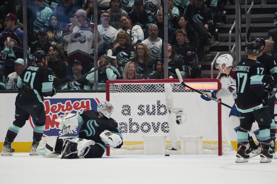 Seattle Kraken's Daniel Sprong (91) and goaltender Philipp Grubauer (31) look on after a goal by Colorado Avalanche center Nathan MacKinnon on Saturday in Seattle.
