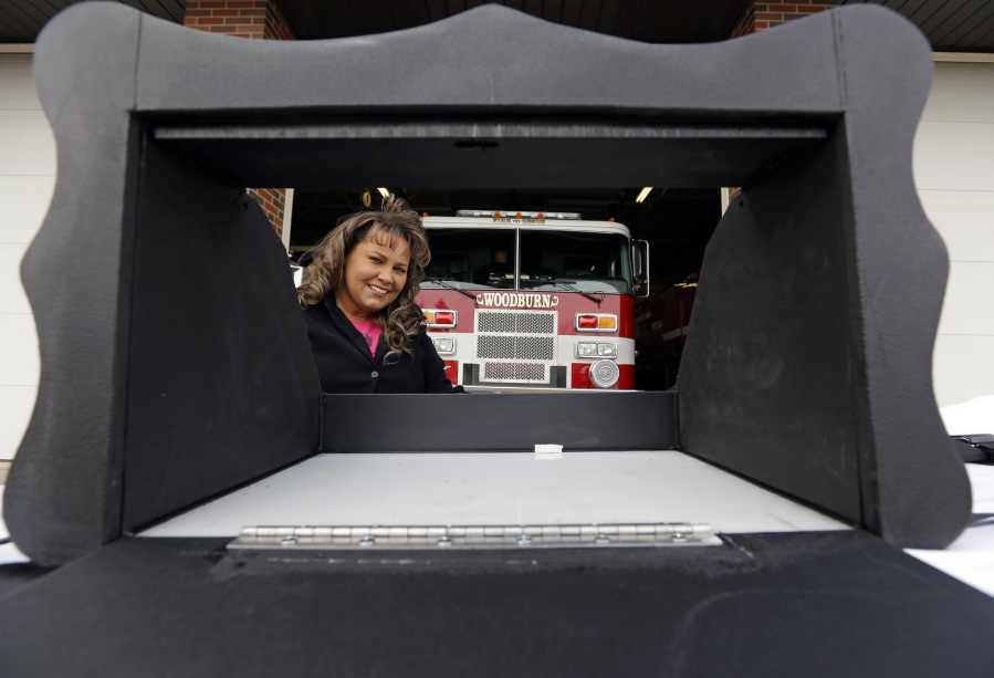 FILE - Monica Kelsey, firefighter and medic who is president of Safe Haven Baby Boxes Inc., poses with a prototype of a baby box, where parents could surrender their newborns anonymously, outside her fire station on Feb. 26, 2015, in Woodburn, Ind. A fight is developing in Florida's legislature over a measure that would allow fire stations and hospitals to install boxes where distressed mothers could leave their unwanted newborns. The Indiana-based group Safe Haven Baby Boxes is pushing the measure.