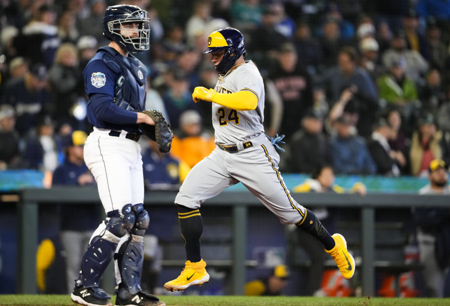 Milwaukee Brewers' William Contreras scores on a single by Luke Voit, while Seattle Mariners catcher Tom Murphy looks to the infield during the seventh inning of a baseball game Wednesday, April 19, 2023, in Seattle.