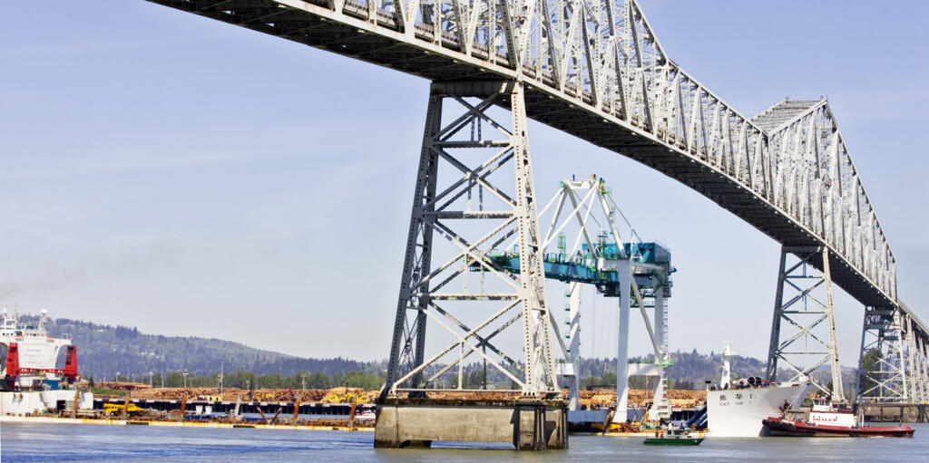 Tugs keep the Zhen Hua creeping slowly up the Columbia River toward the center of the channel so the Port of Portland container crane on board will safely clear the Lewis and Clark Bridge n April 2006, in Longview.