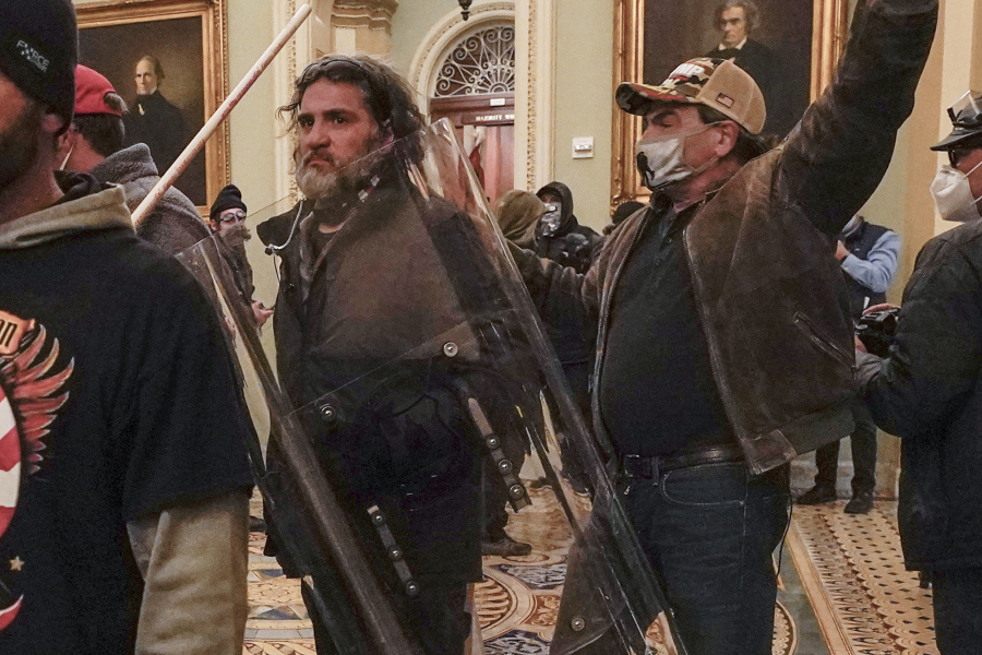 FILE - Rioters, including Dominic Pezzola, center with police shield, are confronted by U.S. Capitol Police officers outside the Senate Chamber inside the Capitol, Wednesday, Jan. 6, 2021, in Washington.