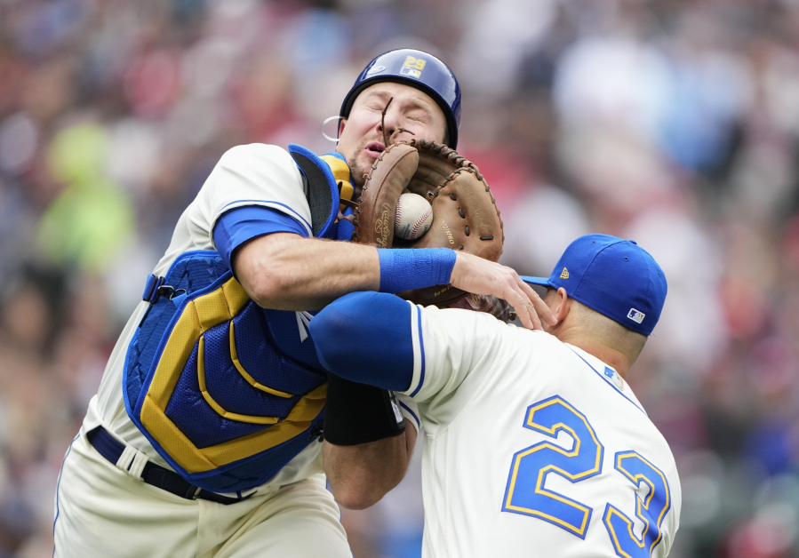 Seattle Mariners catcher Cal Raleigh, left, collides with first baseman Ty France (23) as he catches a foul ball for an out against St. Louis Cardinals' Dylan Carlson during the seventh inning of a baseball game Sunday, April 23, 2023, in Seattle.