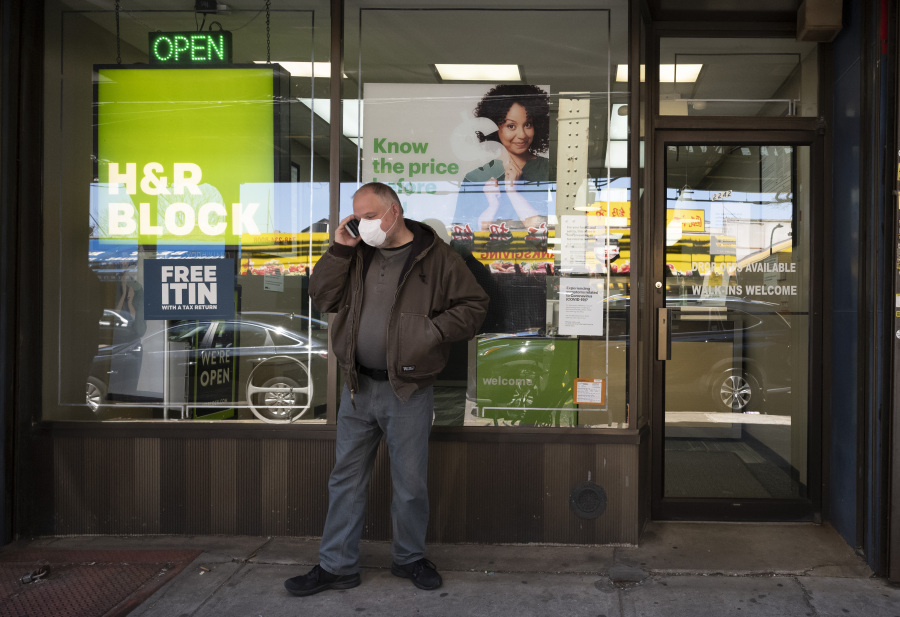 FILE - A man waits outside a H&R Block tax preparation office on Monday, April 6, 2020, in the Brooklyn borough of New York. Tax season is here again. Whether you do your taxes by yourself, go to a tax clinic or hire a professional, navigating the tax system can be complicated.