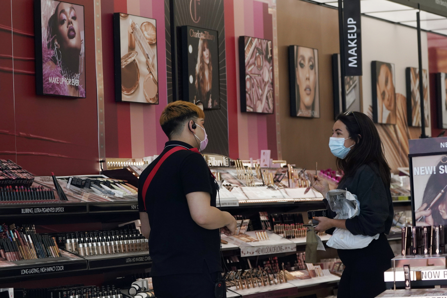 FILE - A worker, at left, tends to a customer at a cosmetics shop on Thursday, May 20, 2021, in Los Angeles.A growing number of state legislatures are considering banning the sale of cosmetics and other consumer products that contain the toxic industrial compound PFAS over health concerns.