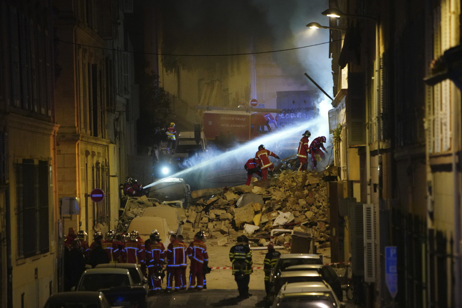 Firefighters work after building collapsed early Sunday, April 9, 2023 in Marseille, southern France. A residential building in France's port city of Marseille collapsed in a loud explosion early Sunday followed by a fire deep within the rubble that hindered rescue efforts.
