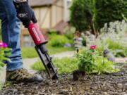 This image provided by Rotoshovel shows a gardener digging a hole with the handheld power digger, one of many available tools designed to make gardening easier.