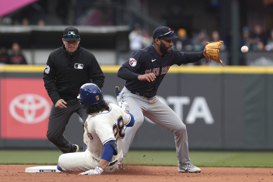 Seattle Mariners' Eugenio Suarez, front left, is safe at second base as Cleveland Guardians shortstop Amed Rosario, right, receives the throw during the fifth inning of a baseball game, Sunday, April 2, 2023, in Seattle.
