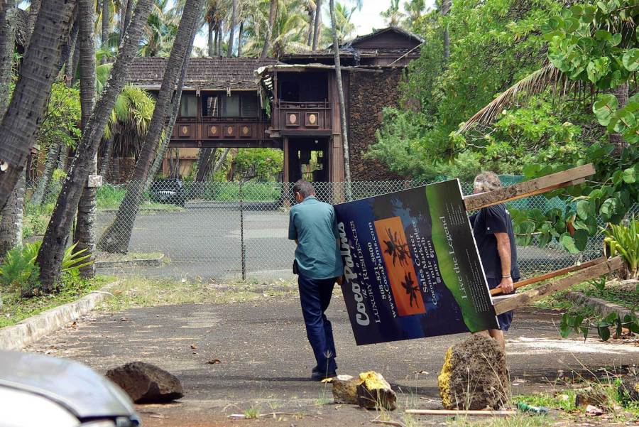 FILE - Workers move the Coco Palms Resort unit sales sign away from the Kuamoo Road side of the former resort in Wailua, Hawaii, Sept. 13, 2007. Demolition will soon begin on the resort once favored by both Hawaiian and Hollywood royalty before it was heavily damaged by a hurricane three decades ago. The Honolulu Star-Advertiser reports the Coco Palms Resort on the island of Kauai will be torn down for a new 350-room hotel. Construction is expected to take about three years.
