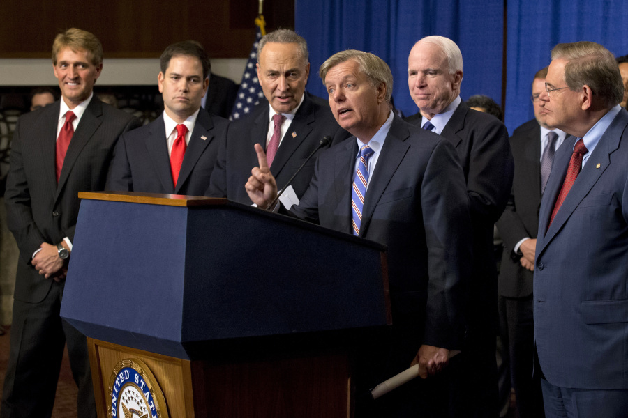 FILE - Sen. Lindsey Graham, R-S.C., center, speaks of immigration reform legislation outlined by the Senate's bipartisan "Gang of Eight" that would create a path for the nation's 11 million unauthorized immigrants to apply for U.S. citizenship, April 18, 2013, on Capitol Hill in Washington. From left are, Sen. Jeff Flake, R-Ariz., Sen. Marco Rubio, R-Fla., Sen. Charles Schumer, Graham, R-S.C., Sen. John McCain, R-Ariz., Sen. Robert Menendez, D-N.J., and Senate Majority Whip Richard Durbin, D-Ill. (AP Photo/J.
