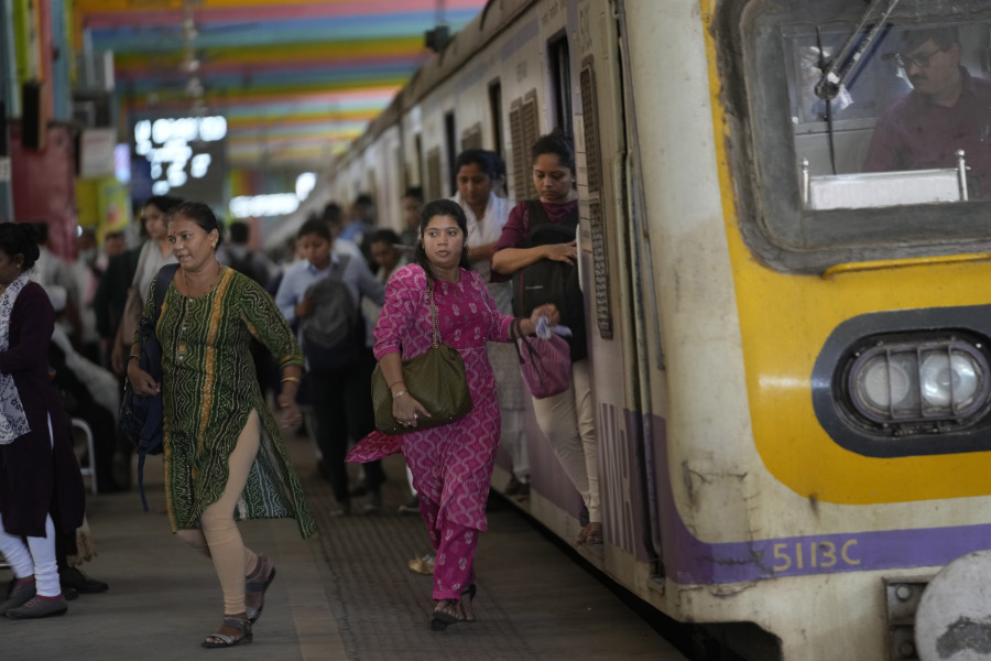 Women rush out of a train during peak hours at Churchgate station in Mumbai, India, Monday, March 20, 2023. 39 million women are employed in India's workforce compared to 361 million men, according to the Center for Monitoring the Indian Economy (CMIE).