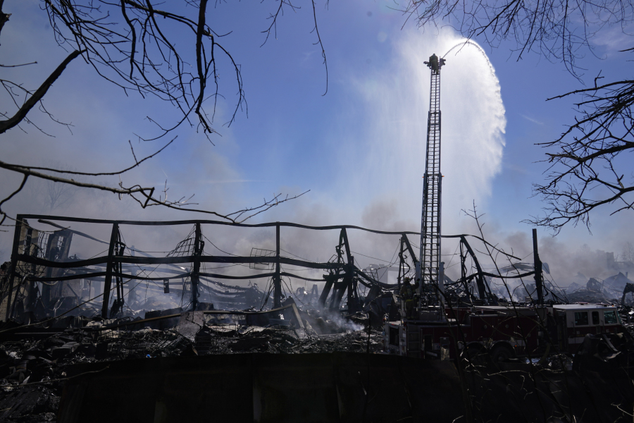 Firefighters pour water on an industrial fire in Richmond, Ind., Thursday, April 13, 2023. Multiple fires that began burning Tuesday afternoon were still burning within about 14 acres of various types of plastics stored inside and outside buildings at the former factory site.
