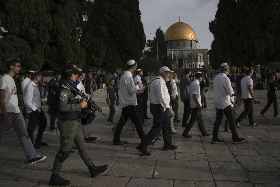 Israeli police escort Jewish visitors marking the holiday pf Passover to the Al-Aqsa Mosque compound, known to Muslims as the Noble Sanctuary and to Jews as the Temple Mount, in the Old City of Jerusalem during the Muslim holy month of Ramadan, Sunday, April 9, 2023.