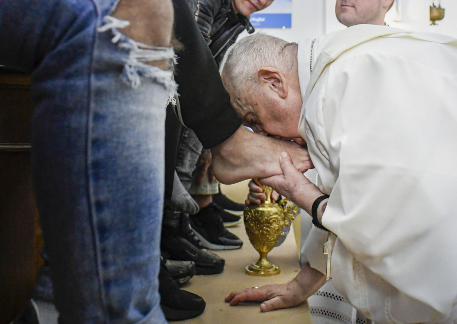 In this picture made available by Vatican Media Pope Francis kisses the feet of the inmates of Rome's penitentiary of Casal del Marmo, Thursday, April 6, 2023. In a Holy Thursday ritual symbolizing humility, Pope Francis washed and wiped dry the bare feet of a dozen residents of a Rome juvenile prison, assuring them of their dignity and telling them "any of us" can fall into sin.