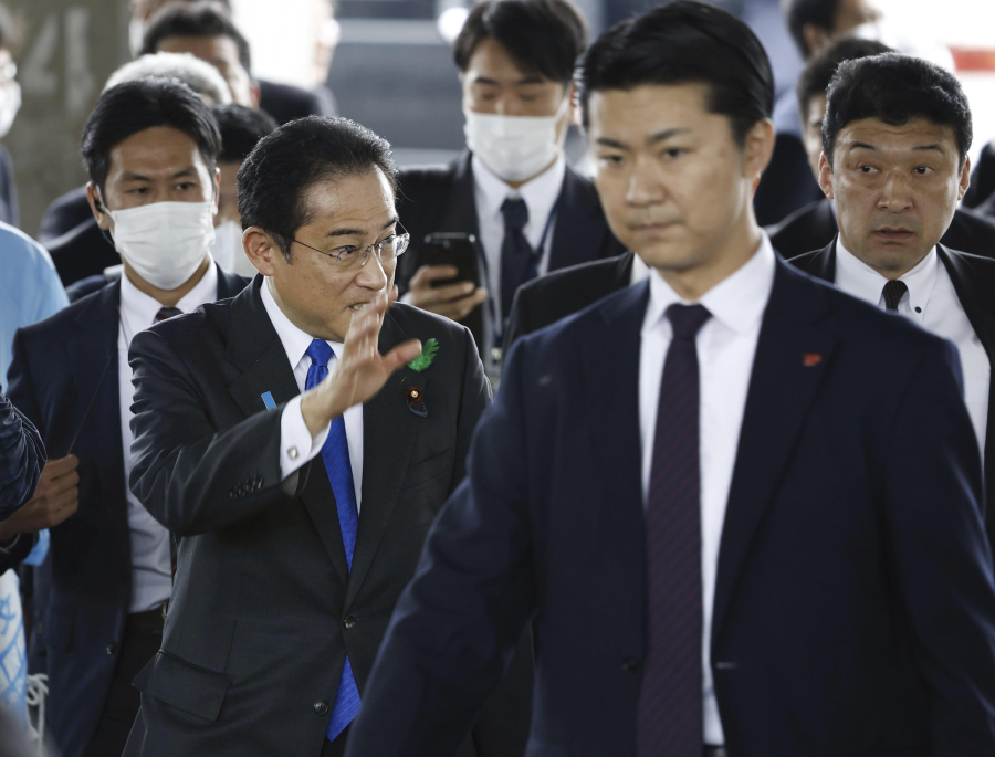 Japanese Prime Minister Fumio Kishida, left, surrounded by security police, arrives at the Saikazaki port for an election campaign event in Wakayama, western Japan Saturday, April 15, 2023.
