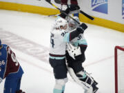 Seattle Kraken goaltender Philipp Grubauer, right, celebrates with defenseman Jamie Oleksiak as Colorado Avalanche right wing Mikko Rantanen heads off the ice as time runs out in the third period of Game 7 of an NHL first-round playoff series Sunday, April 30, 2023, in Denver. The Kraken won 2-1 to advance to the next round.