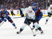 Seattle Kraken center Ryan Donato (9) is defended by Colorado Avalanche center Lars Eller (20) during the second period of Game 2 of a first-round NHL hockey playoff series Thursday, April 20, 2023, in Denver.