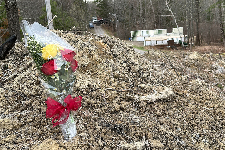 A lone bouquet of flowers marks a desolate makeshift memorial at the end of a driveway at a Bowdoin, Maine, home, Wednesday, April 19, 2023, where police say four people were killed.  A Maine man who police say killed four people in a home and then shot three others randomly on a busy highway had been released days earlier from prison, a state official said Wednesday.