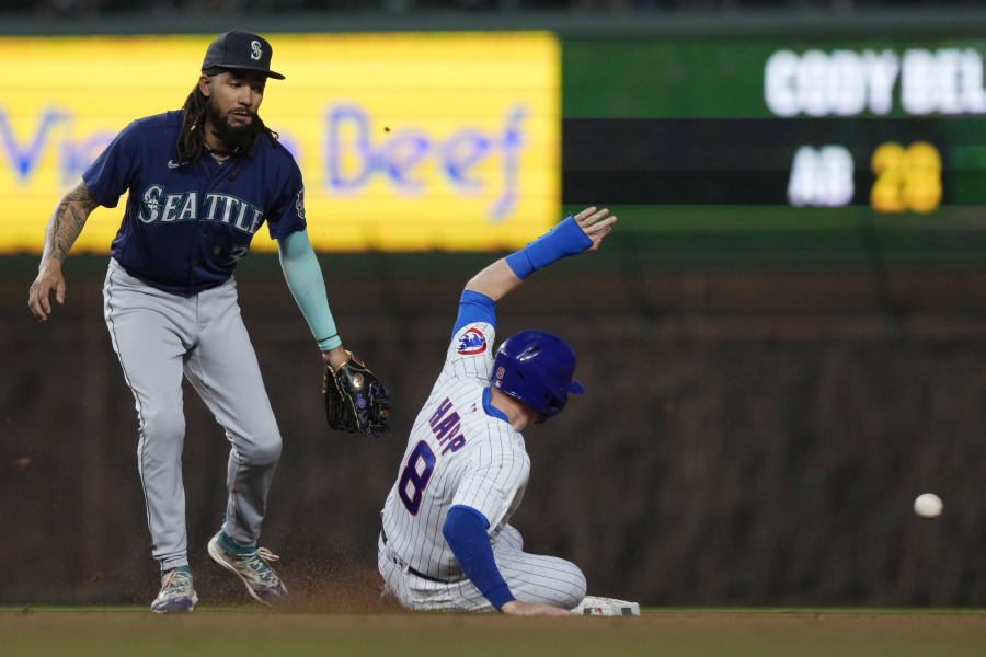 Chicago Cubs' Ian Happ, right, steals second base as Seattle Mariners shortstop J.P. Crawford, left, misses a catch during the fourth inning of a baseball game in Chicago, Monday, April 10, 2023. (AP Photo/Nam Y.