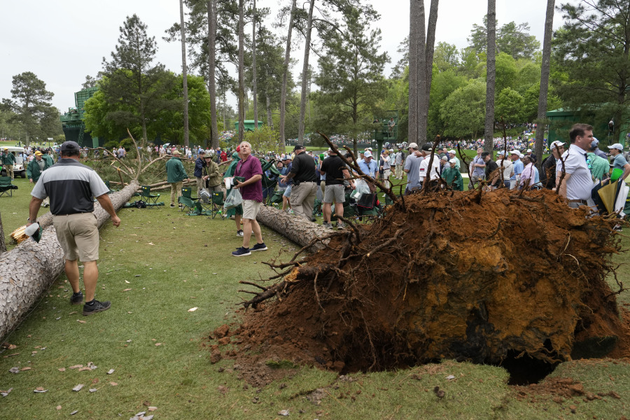 Patrons move away from two trees that blew over on the 17th hole during the second round of the Masters golf tournament at Augusta National Golf Club on Friday, April 7, 2023, in Augusta, Ga.