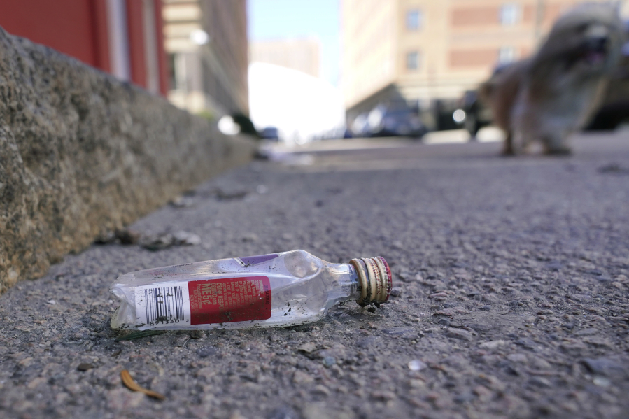 An empty miniature bottle that once contained liquor rests on a street near a sidewalk, Monday, April 3, 2023, in Boston.  A Boston city councilor has proposed barring city liquor stores from selling the single-serve bottles that hold 100 milliliters or less of booze both as a way to address alcohol abuse and excessive litter.
