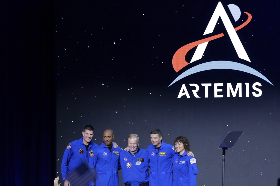 NASA Administrator Bill Nelson, center, joins astronauts, from left, Jeremy Hansen, Victor Glover, Reid Wiseman and Christina Hammock Koch, as they are announced as the Artemis II crew during a NASA ceremony naming the four astronauts who will fly around the moon by the end of next year, at a ceremony held in the NASA hanger at Ellington airport Monday, April 3, 2023, in Houston.