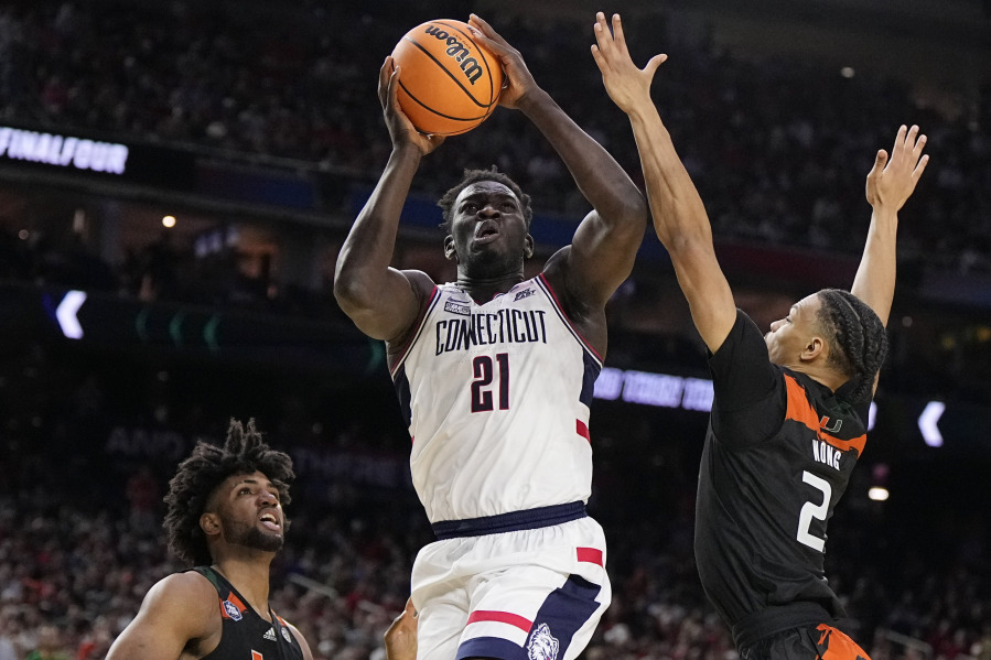 Connecticut forward Adama Sanogo scores past Miami guard Isaiah Wong during the second half of a Final Four college basketball game in the NCAA Tournament on Saturday, April 1, 2023, in Houston.