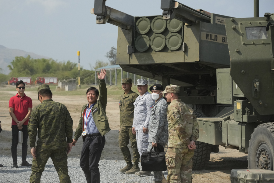 Philippine President Ferdinand Marcos Jr. waves beside a U.S. M142 High Mobility Artillery Rocket System (HIMARS) during a Combined Joint Littoral Live Fire Exercise at the joint military exercise called "Balikatan," Tagalog for shoulder-to-shoulder in a Naval station in Zambales province, northern Philippines on Wednesday, April 26, 2023. The long-time treaty allies are holding their largest joint military exercises that are part of a show of American firepower that has alarmed China.