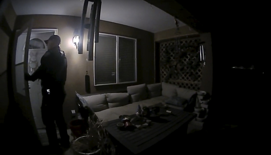 In this image taken from body camera video provided by the Farmington Police Department, a police officer knocks on the door of the wrong address in response to a domestic violence call, in Farmington, N.M., late April 5, 2023. Moments later, the homeowner was fatally shot by police after appearing at the door armed with a handgun.