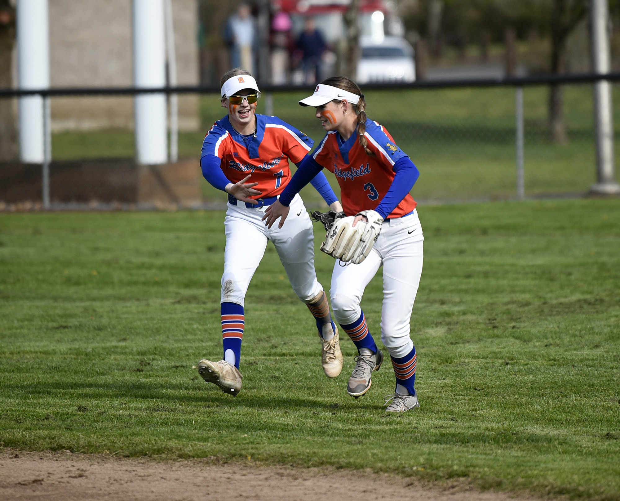 Ridgefield outfielders Charlie Harris (7) and Tava Whitlow (3) greet each other after Whitlow made a catch in the outfield during Ridgefield’s 19-6 win over Columbia River in a 2A Greater St. Helens League softball game at VGSA on Thursday, April 13, 2023.