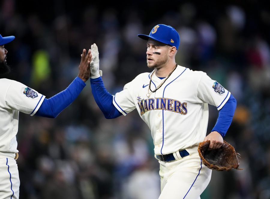 Seattle Mariners' Jarred Kelenic, right, high-fives teammate Teoscar Hernandez, left, as they celebrate a 1-0 win over the Colorado Rockies in a baseball game, Sunday, April 16, 2023, in Seattle. Kelenic drove in the only run of the game, an RBI single in the sixth inning to score Ty France.