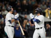 Seattle Mariners' Eugenio Suarez, right, celebrates his solo home run against the Colorado Rockies with Cal Raleigh during the fourth inning of a baseball game Saturday, April 15, 2023, in Seattle.