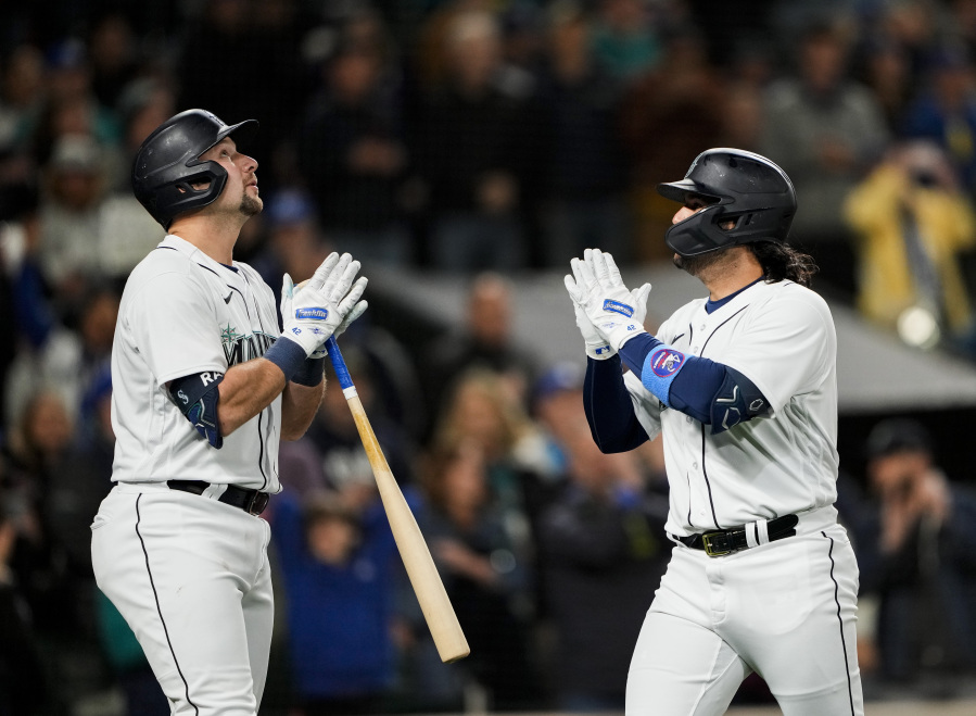 Seattle Mariners' Eugenio Suarez, right, celebrates his solo home run against the Colorado Rockies with Cal Raleigh during the fourth inning of a baseball game Saturday, April 15, 2023, in Seattle.