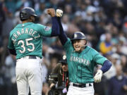 Seattle Mariners left fielder Jarred Kelenic, right, celebrates after his home run with Teoscar Hernandez after they scored off a throw by Colorado Rockies starting pitcher Austin Gomber during a baseball game, Friday, April 14, 2023, in Seattle.