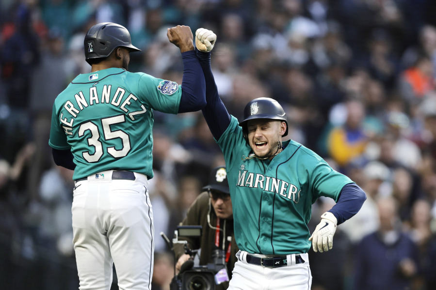 Seattle Mariners left fielder Jarred Kelenic, right, celebrates after his home run with Teoscar Hernandez after they scored off a throw by Colorado Rockies starting pitcher Austin Gomber during a baseball game, Friday, April 14, 2023, in Seattle.