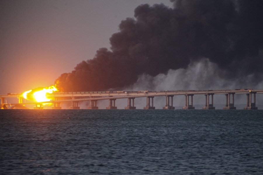 FILE - Flame and smoke rise from Crimean Bridge connecting Russian mainland and Crimean peninsula over the Kerch Strait, after what Russian authorities said was a bomb caused fire and partial collapse of the bridge, in Kerch, Crimea, Saturday, Oct. 8, 2022. A top Ukrainian official on Sunday, April 2, 2023, outlined a series of steps the government in Kyiv would take after the country reclaims control of Crimea, including dismantling the strategic bridge that links the seized Black Sea peninsula to Russia.