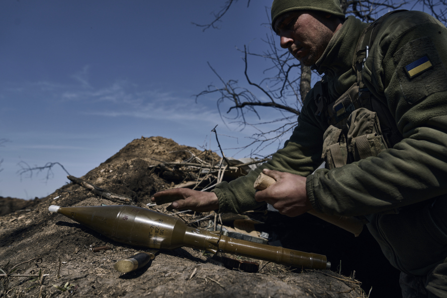 A Ukrainian soldier prepares to fire a grenade launcher on the frontline in Bakhmut, Donetsk region, Ukraine, Monday, April 10, 2023.