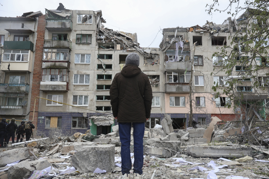 A local resident looks at his home, damaged by a Russian rocket attack in Sloviansk, Donetsk region, Ukraine, Friday, Apr. 14, 2023. The death toll from Russian missile strikes on eastern Ukraine's city of Sloviansk rose to 11 Saturday as rescue crews tried to reach people trapped in the rubble of an apartment building, Ukrainian authorities said.