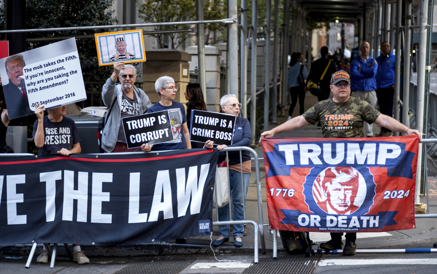 Protesters gather before former President Donald Trump arrives in a motorcade for a deposition in New York Thursday, April 13, 2023.