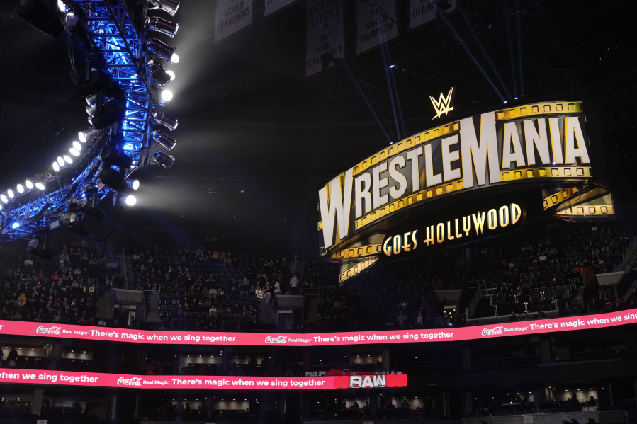 A WrestleMania sign hangs over the crowd during the WWE Monday Night RAW event, Monday, March 6, 2023, in Boston. WWE's WrestleMania arrives this weekend, Saturday, April 1, to a massive audience and vastly larger advertising revenue as it seeks to establish itself as a serious contender for major advertising bucks.