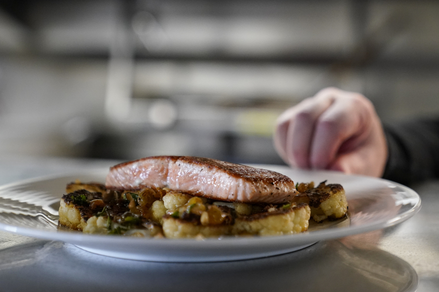 FILE - A farm-raised salmon dish at Scoma's sits before being served to a customer in San Francisco, March 20, 2023. A federal regulatory group has voted to officially close king salmon fishing season along much of the West Coast after near-record low numbers of the fish, also known as Chinook, returned to California's rivers in 2022. (AP Photo/Godofredo A.