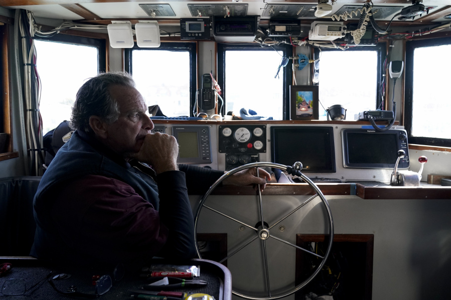 Bob Maharry sits inside his fishing boat docked at Pier 45 in San Francisco, Monday, March 20, 2023. This would usually be a busy time of year for Maharry and his crew as salmon fishing season approaches. On April 7, the Pacific Fishery Management Council, the regulatory group that advises federal officials, will take action on what to do about the 2023 season for both commercial and recreational salmon fishing. (AP Photo/Godofredo A.