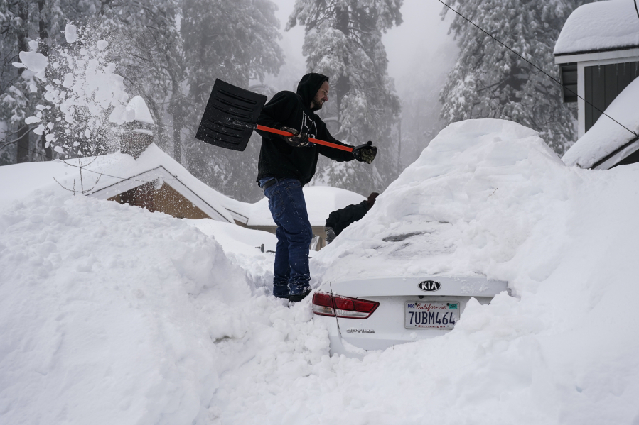 FILE - Kenny Rybak shovels snow around his car in Running Springs, Calif., Tuesday, Feb. 28, 2023. Since December, 2022, a parade of a dozen atmospheric storms have dumped so much snow up and down the Sierra that several ski resorts around Lake Tahoe have had to shut down multiple times. The National Weather Service in Reno recently called it the "winter that just doesn't want to end." (AP Photo/Jae C.